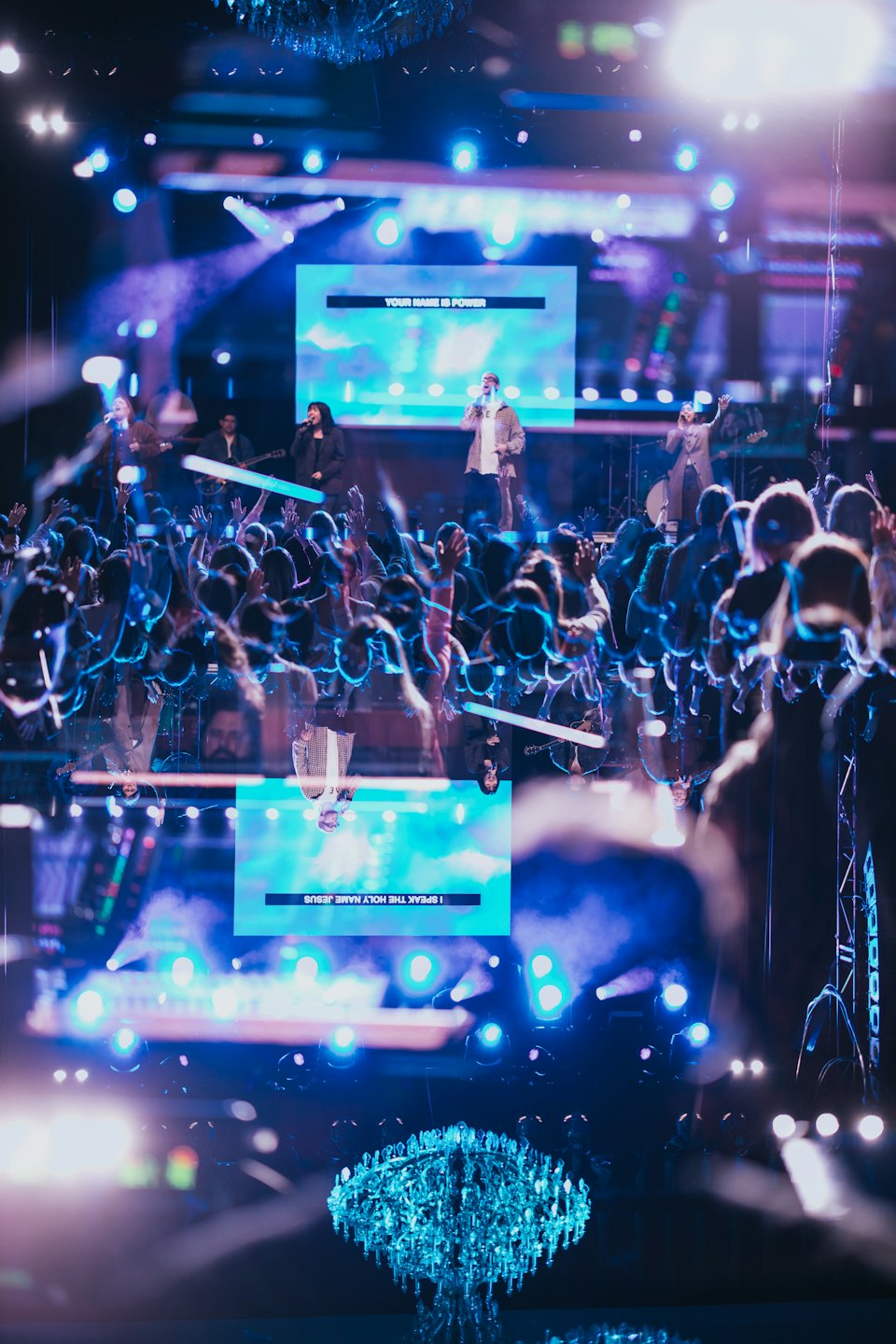 Band performs on stage with crowd hands raised.