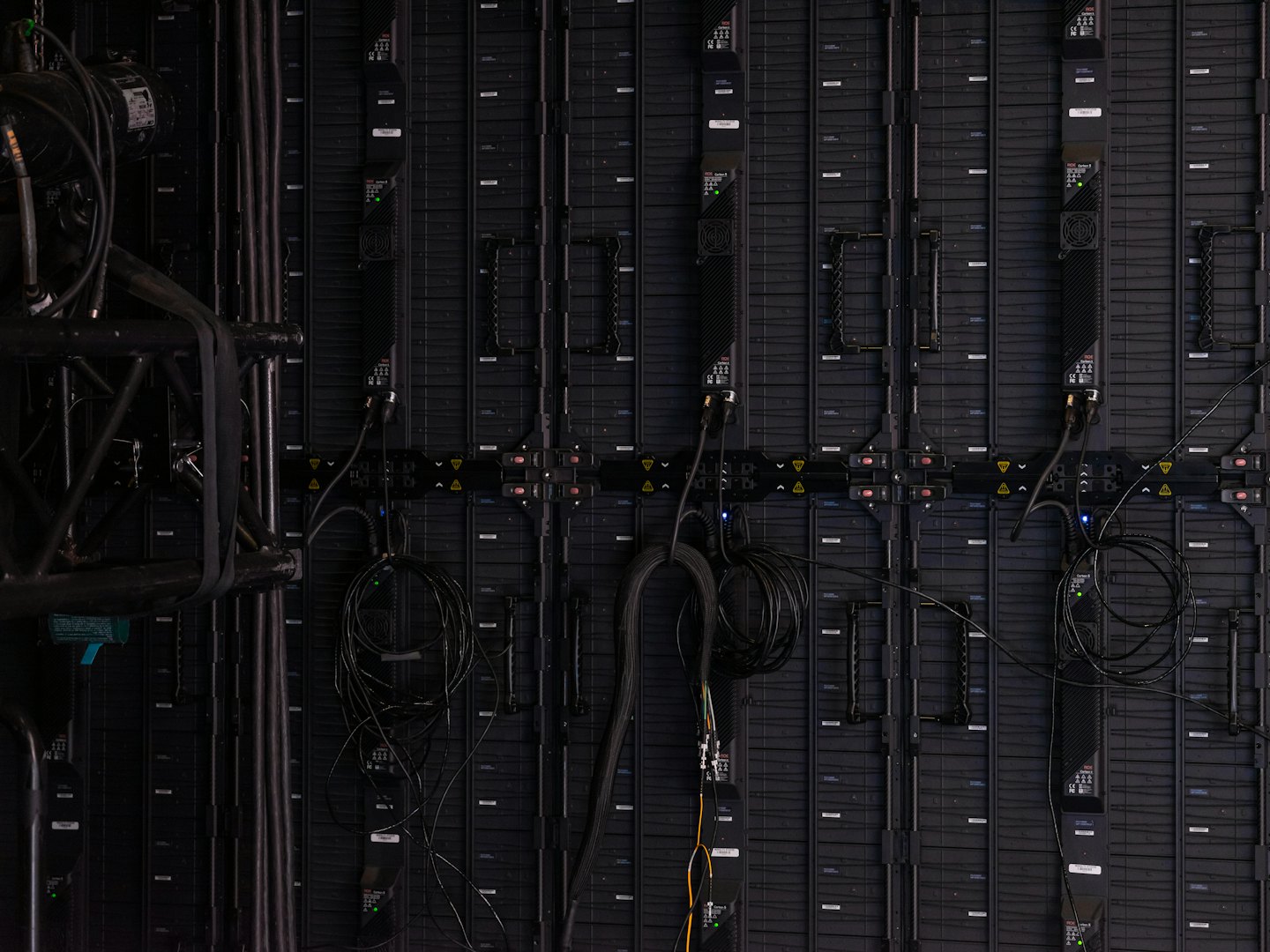 Rear view of an LED video wall with cables and truss.