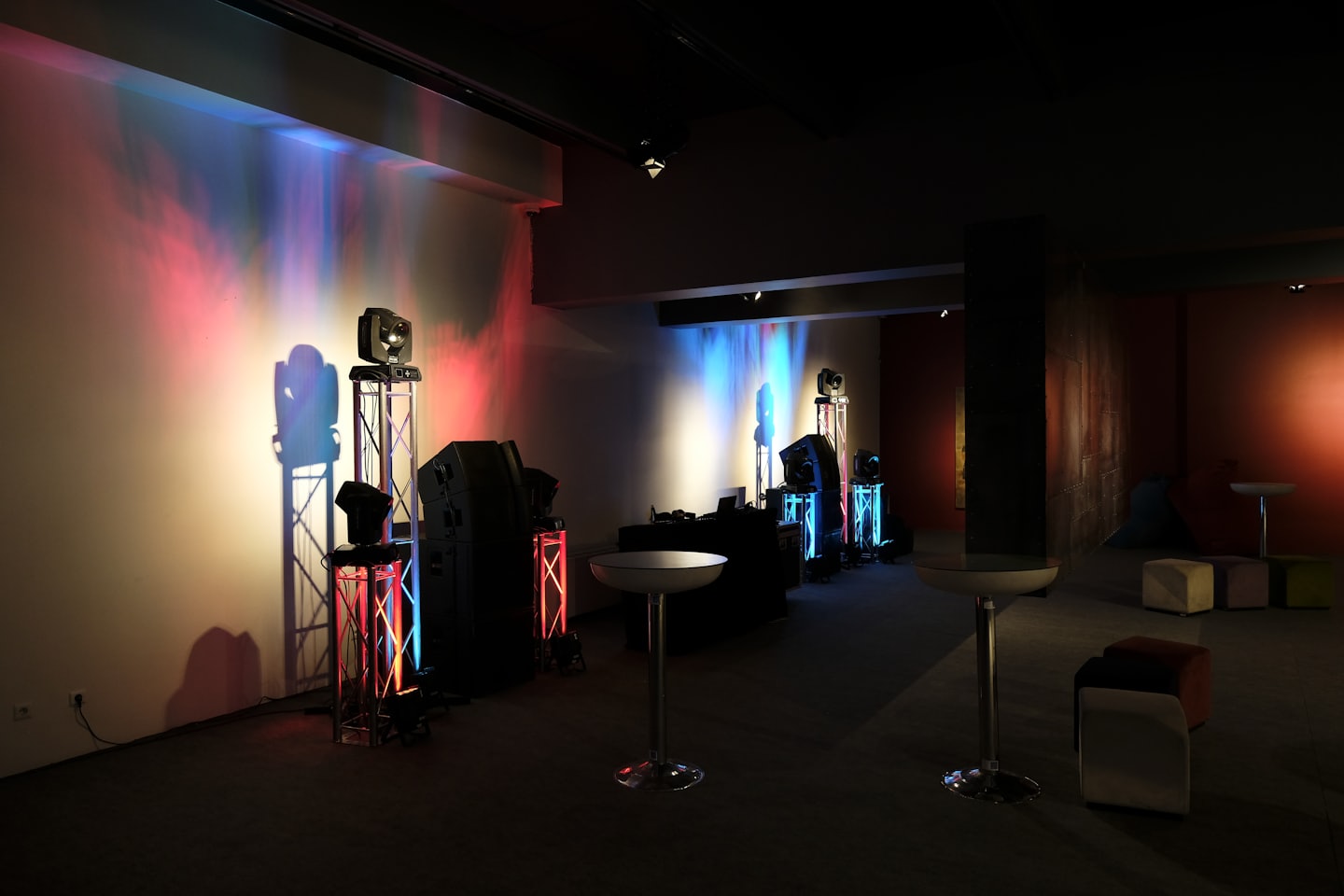 Event space prepared with stage lights and lounge furniture.