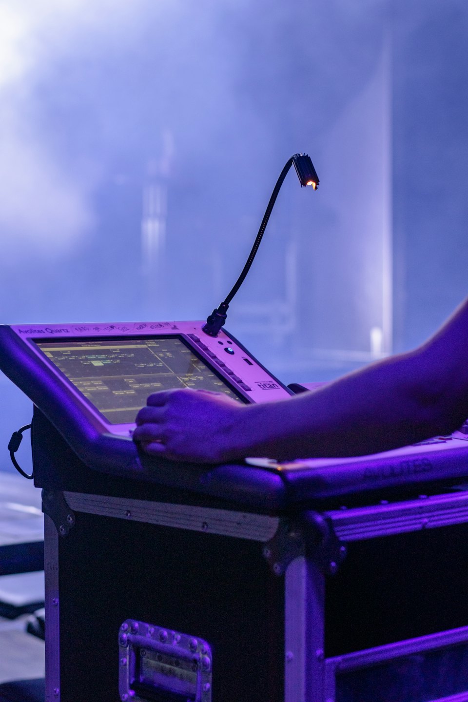 Sound engineer adjusts controls on a digital console during a live event.